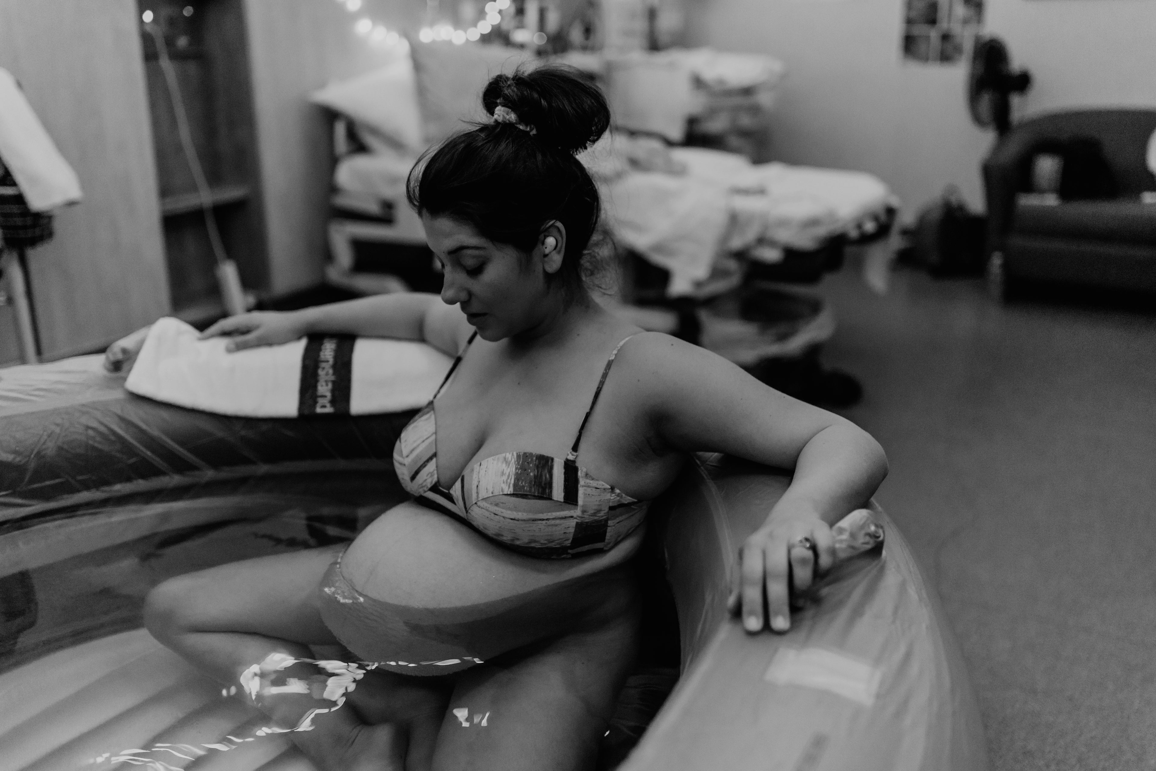 Water birth scene with a woman holding a wooden birth comb from The Birth Teacher in Emerald QLD, Australia
