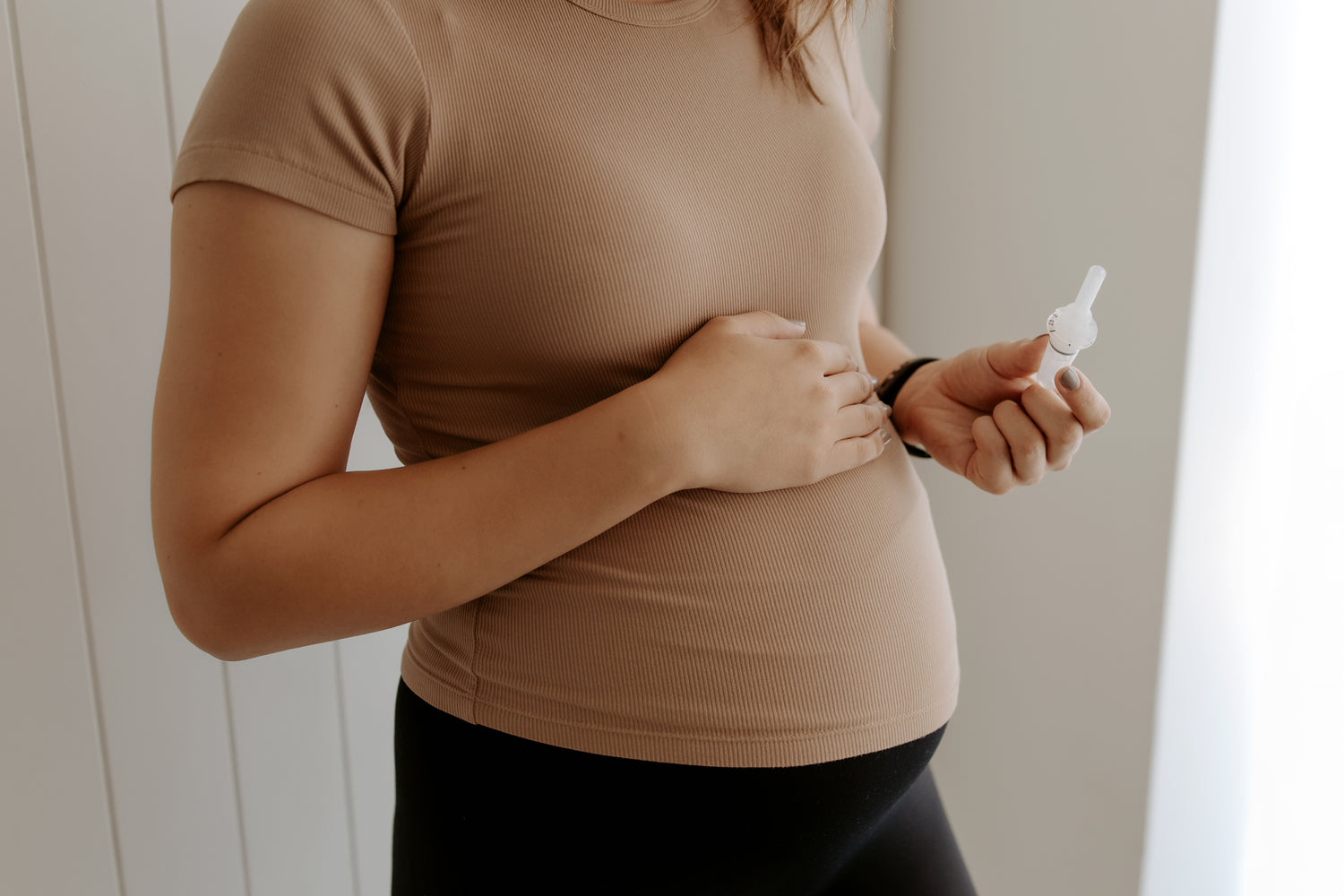 "Pregnant woman holding the WinnerFlow breathwork device, available exclusively through The Birth Teacher Australia"