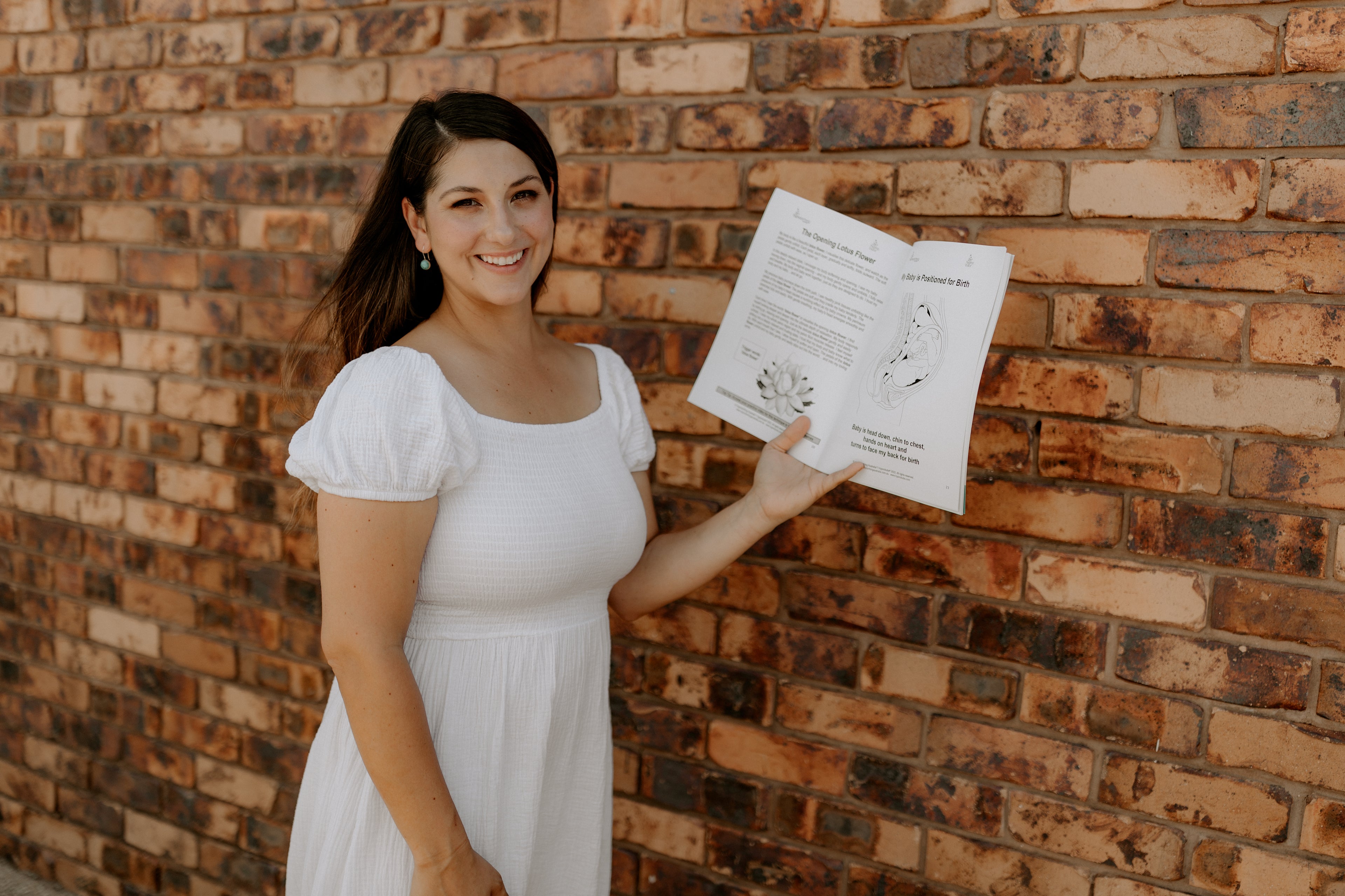 Birth educator in Emerald QLD holding a book on childbirth, part of The Birth Teacher resources