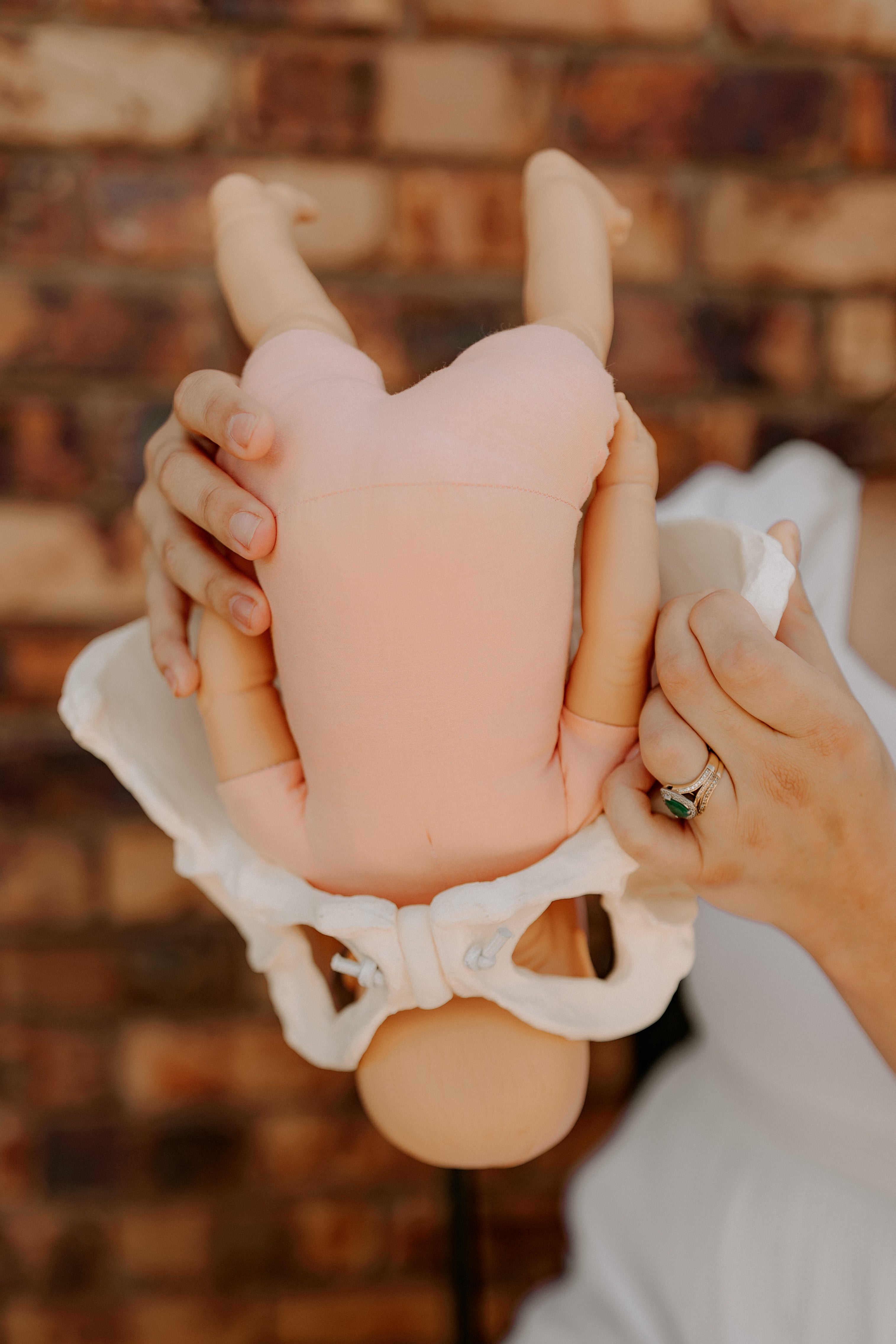 "The Birth Teacher demonstrating the birth process with a doll passing through a pelvis model in Emerald QLD, Australia"