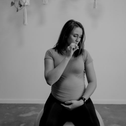 Black and white photo of a woman sitting on a yoga ball using with a neutral background using WinnerFlow device