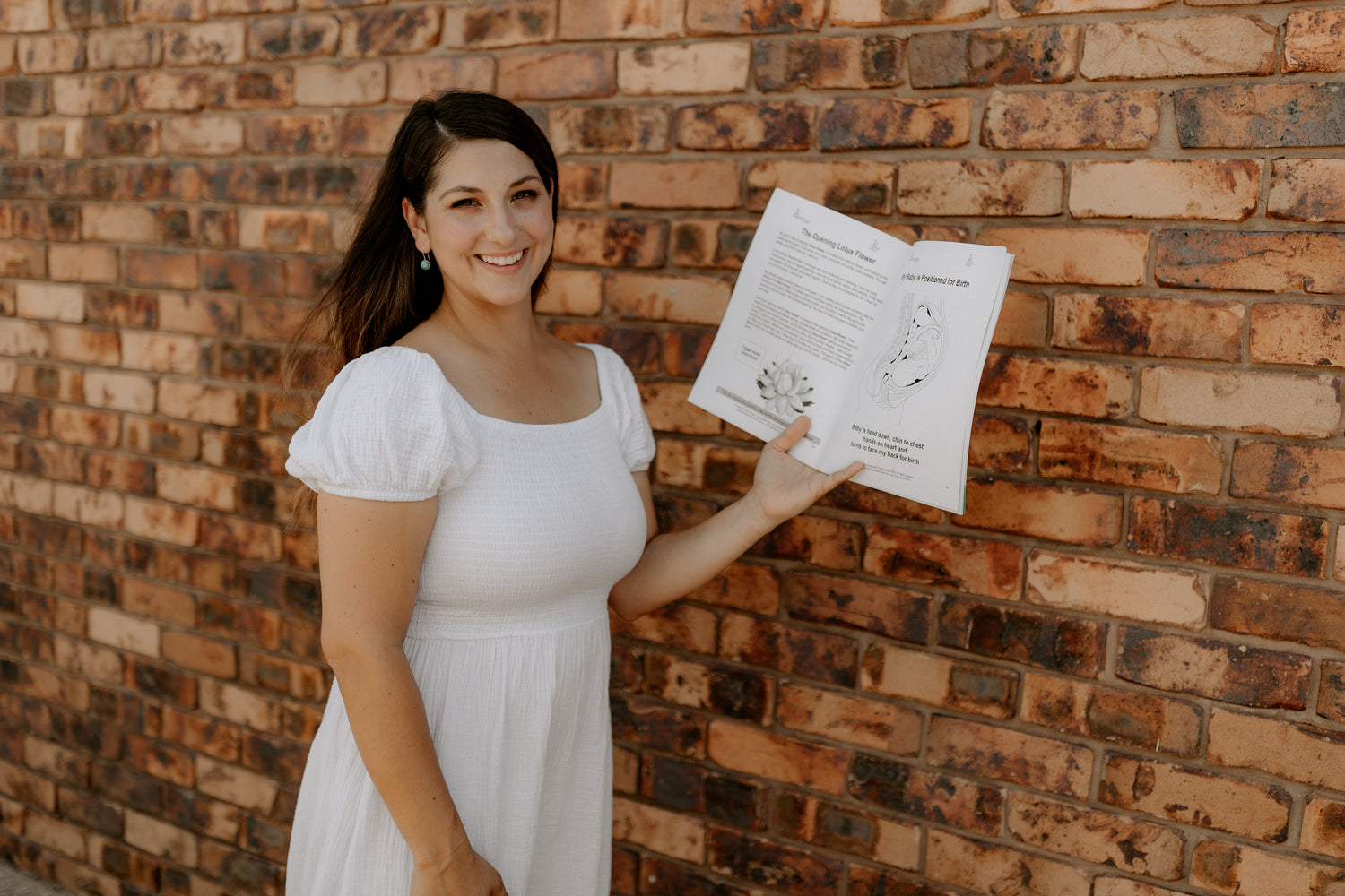 Birth educator in Emerald QLD holding a book on childbirth, part of The Birth Teacher resources